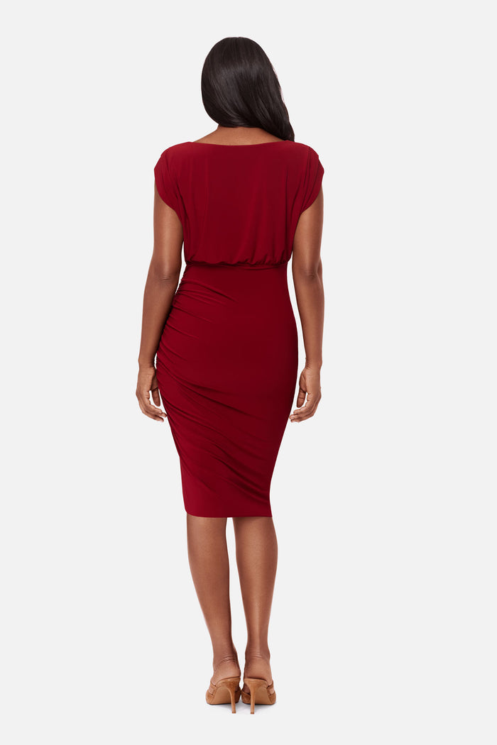 Woman turned away wearing a bright red dress with a high neckline