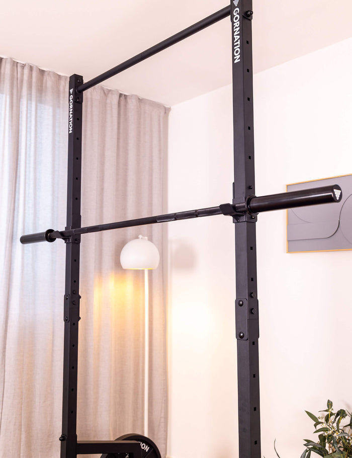 GORNATION barbell laying on the squat rack holder from a pull up station