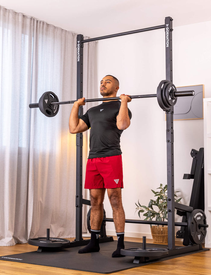 GORNATION athlete performing shoulder presses with a GORNATION barbell