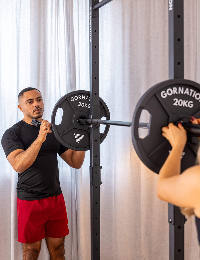 GORNATION athlete loading a GORNATION barbell with weight plates