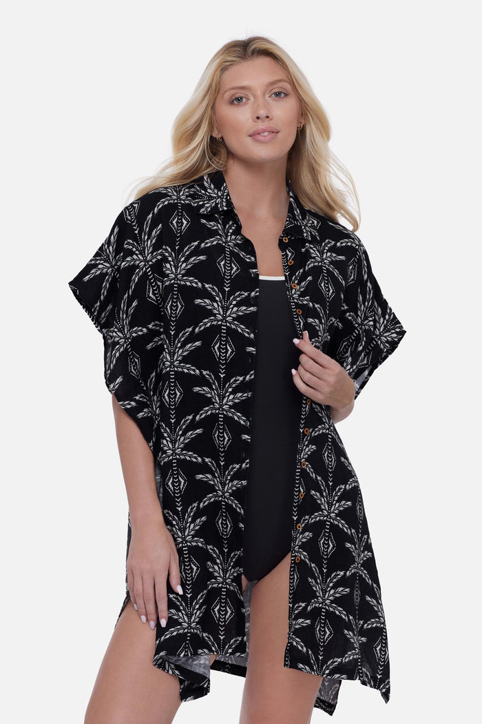 Woman wearing a black and white palm leaf printed swim cover up shirt