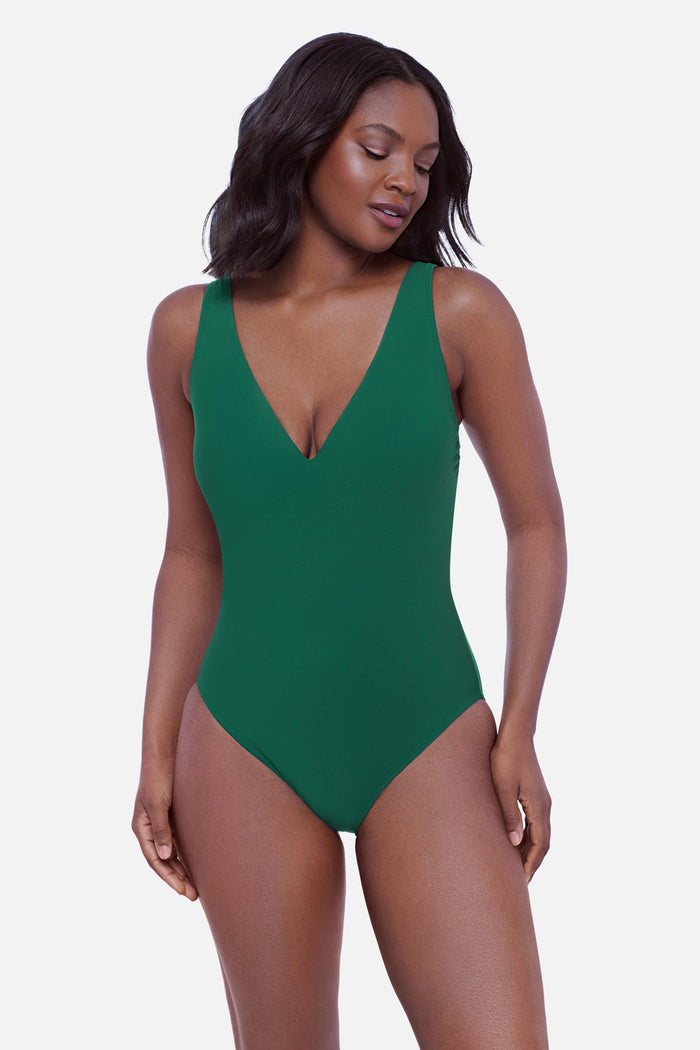 Woman wearing a green one-piece swimsuit with a V neckline