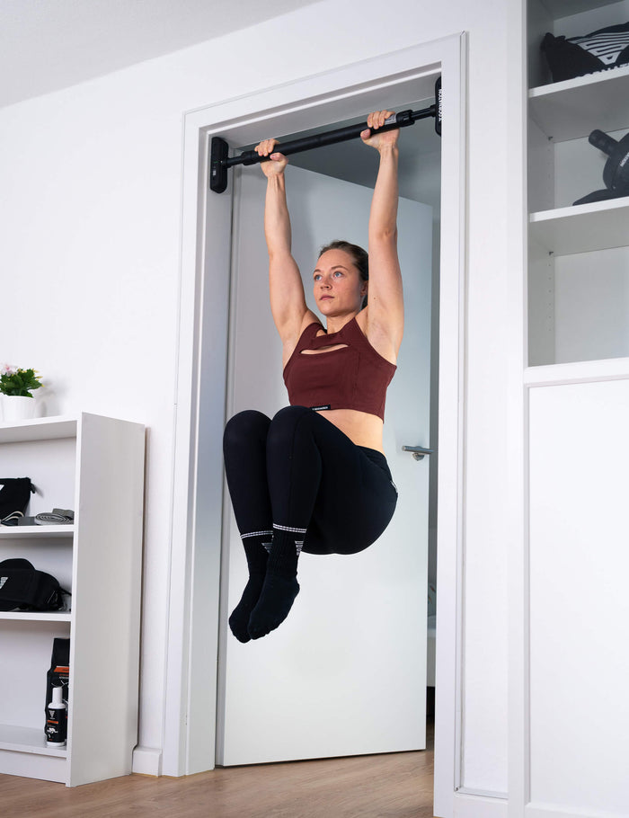 GORNATION athlete performing knee raises on the door pull up bar Extend-It
