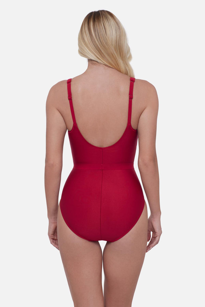 Woman faced away wearing a cherry red one-piece swimsuit with belt