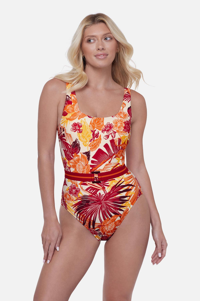 Woman wearing a multicolored palm leaf printed one-piece swimsuit with a belt