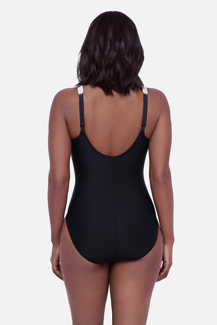 Woman turned away wearing a tropical scene printed one-piece swimsuit