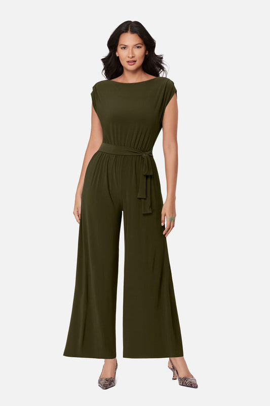 Woman wearing a green romper with a sash around the waist