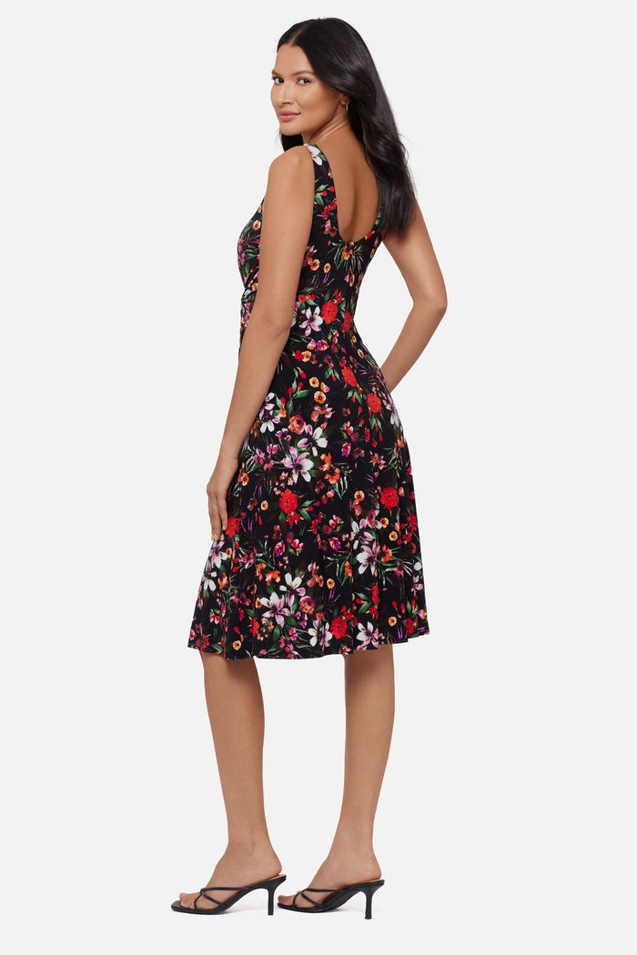 Woman turned left wearing a multicolored floral printed sleeveless mid length dress