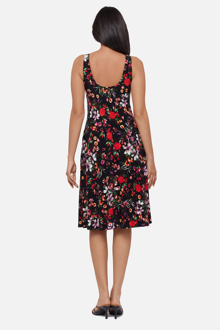 Woman turned away wearing a multicolored floral printed sleeveless mid length dress