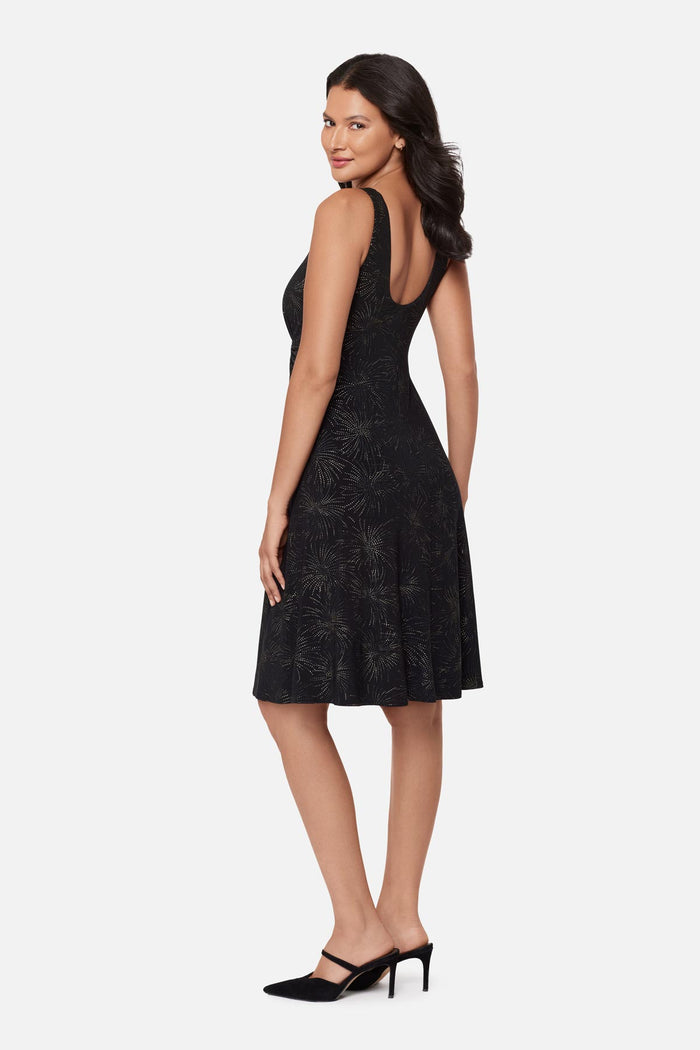 Woman turned left wearing a black sparkle printed knee length dress