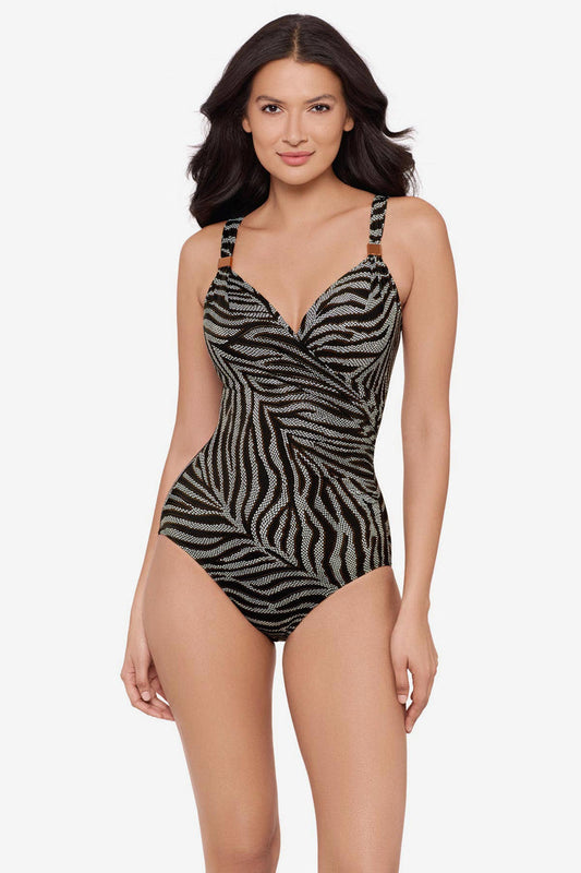 Woman wearing an animal print-esque one-piece swimsuit with embellishments on the straps