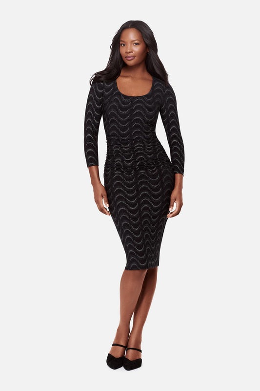Woman wearing a black long sleeve dress with a glittery wave pattern